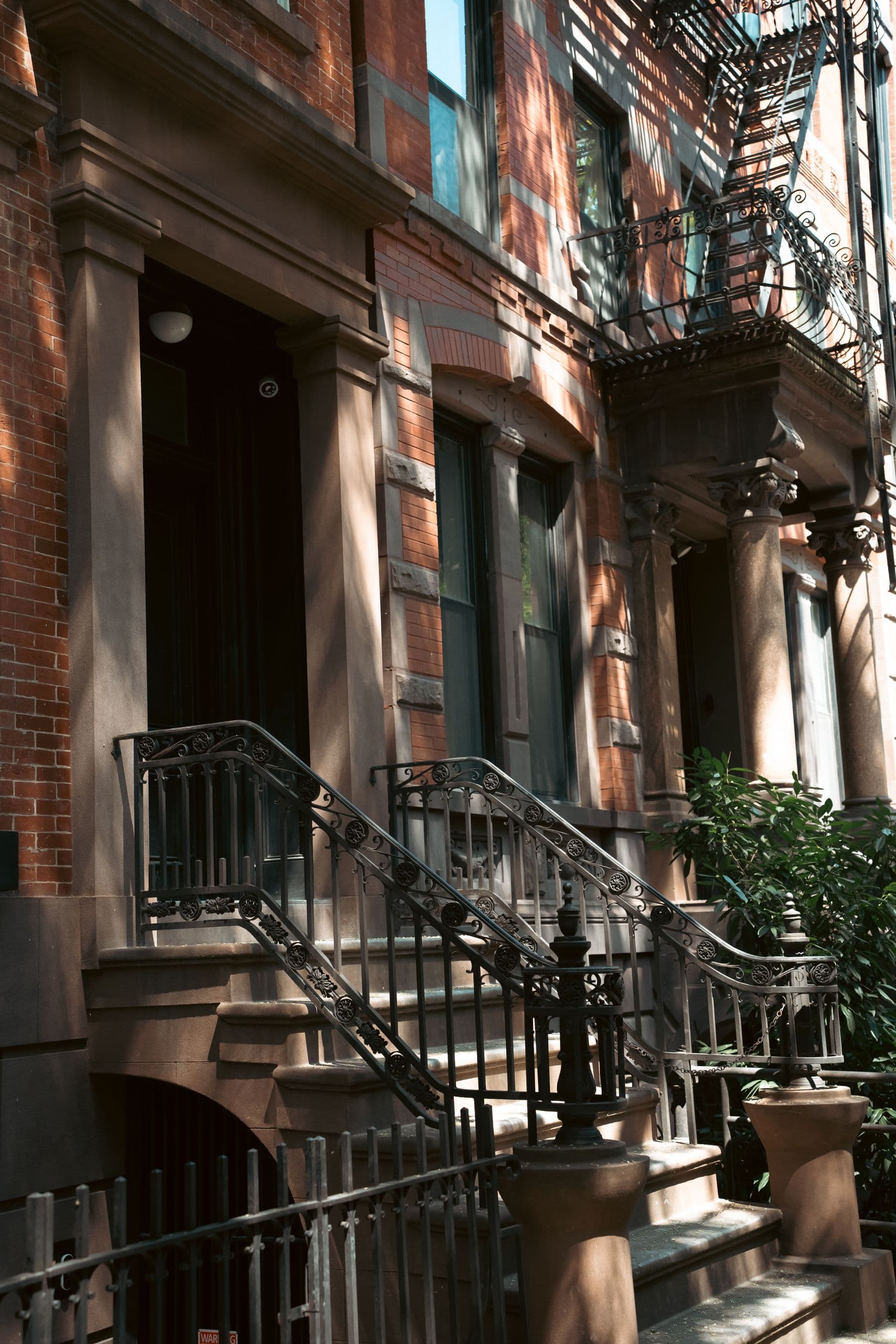 Historic New York brownstone entrance with masonry detailing and ornamental ironwork